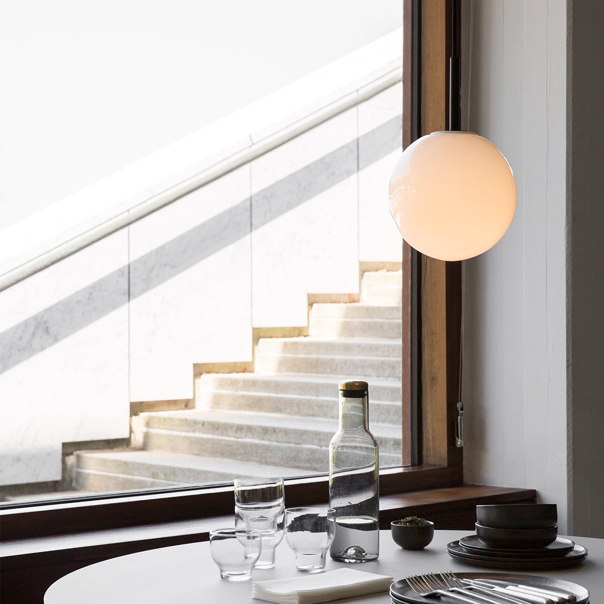 Hanging bulb in dining room setting next to big open window