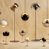 A group of floor, table and pendant lamps with half-dome shades in brass, chrome, black and white