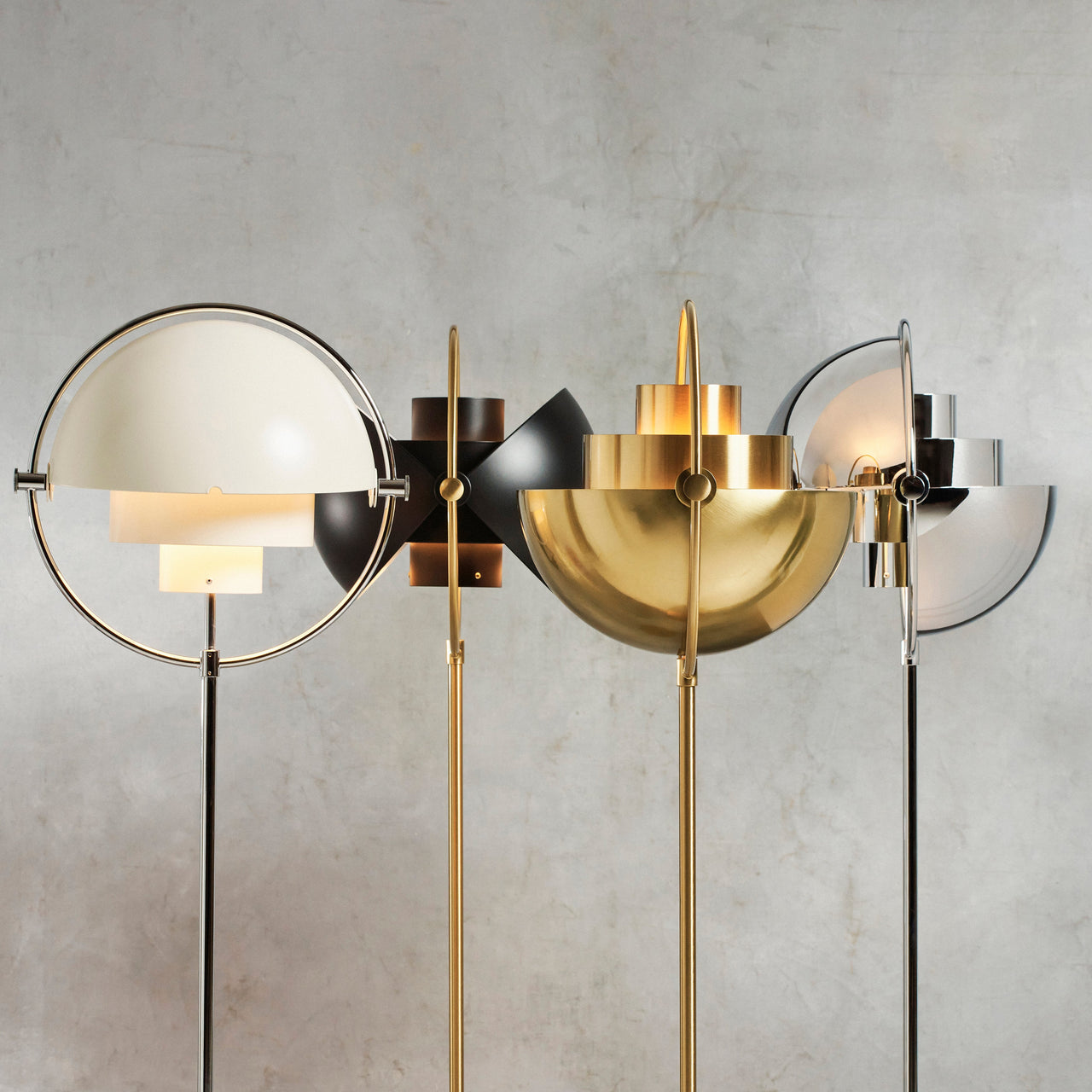 Four floor lamps with swivelling half-dome shades in white, black, brass and chrome