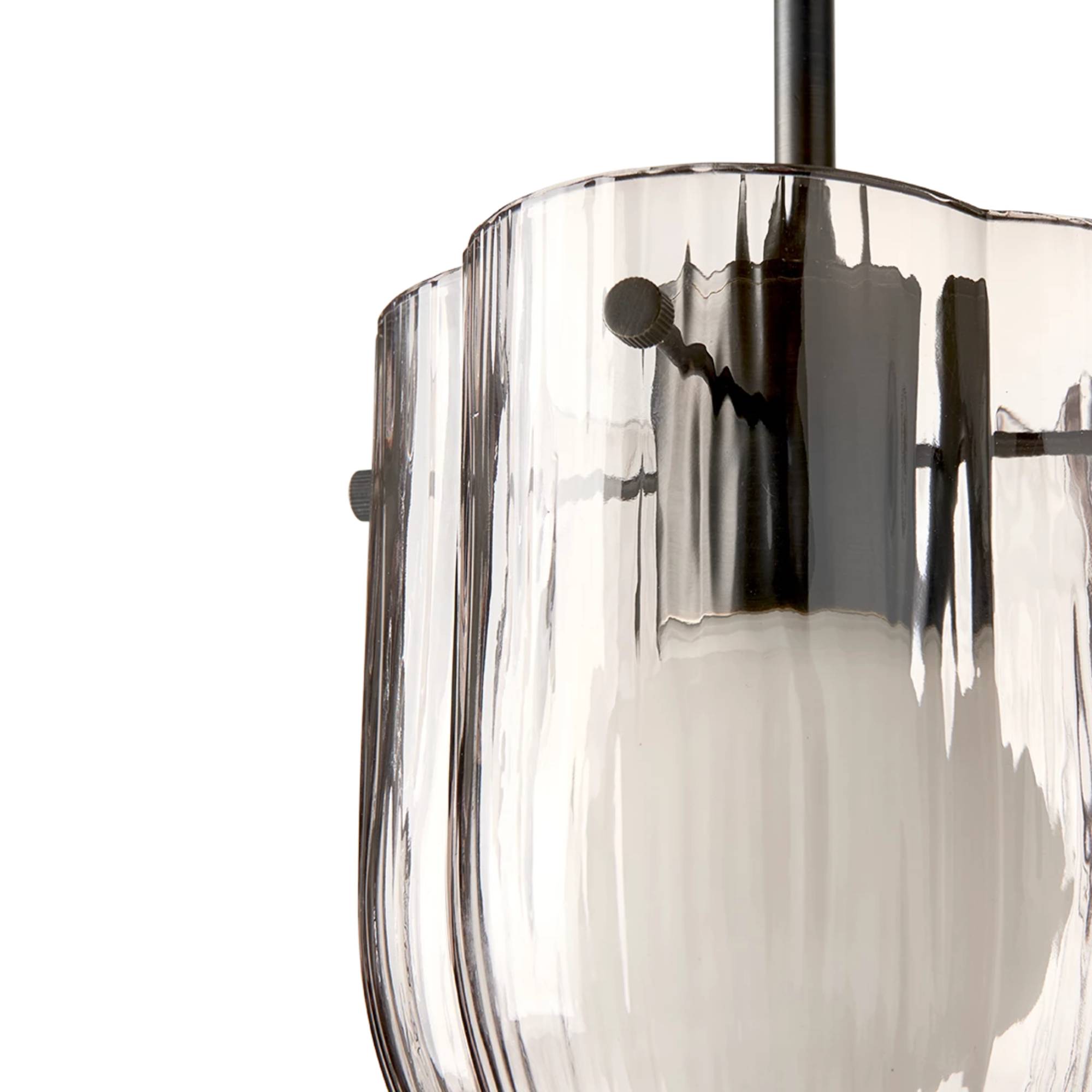 Close-up of a pendant light with a ribbed smoked glass shade, scalloped rim and dark metal rod