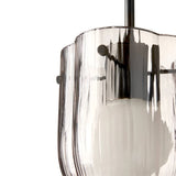 Close-up of a pendant light with a ribbed smoked glass shade, scalloped rim and dark metal rod