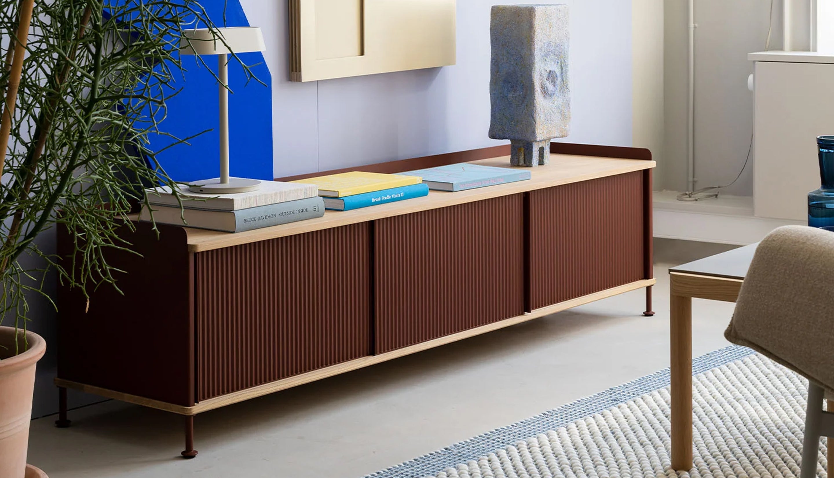 Brown sideboard in a modern living room with coffee table books on top