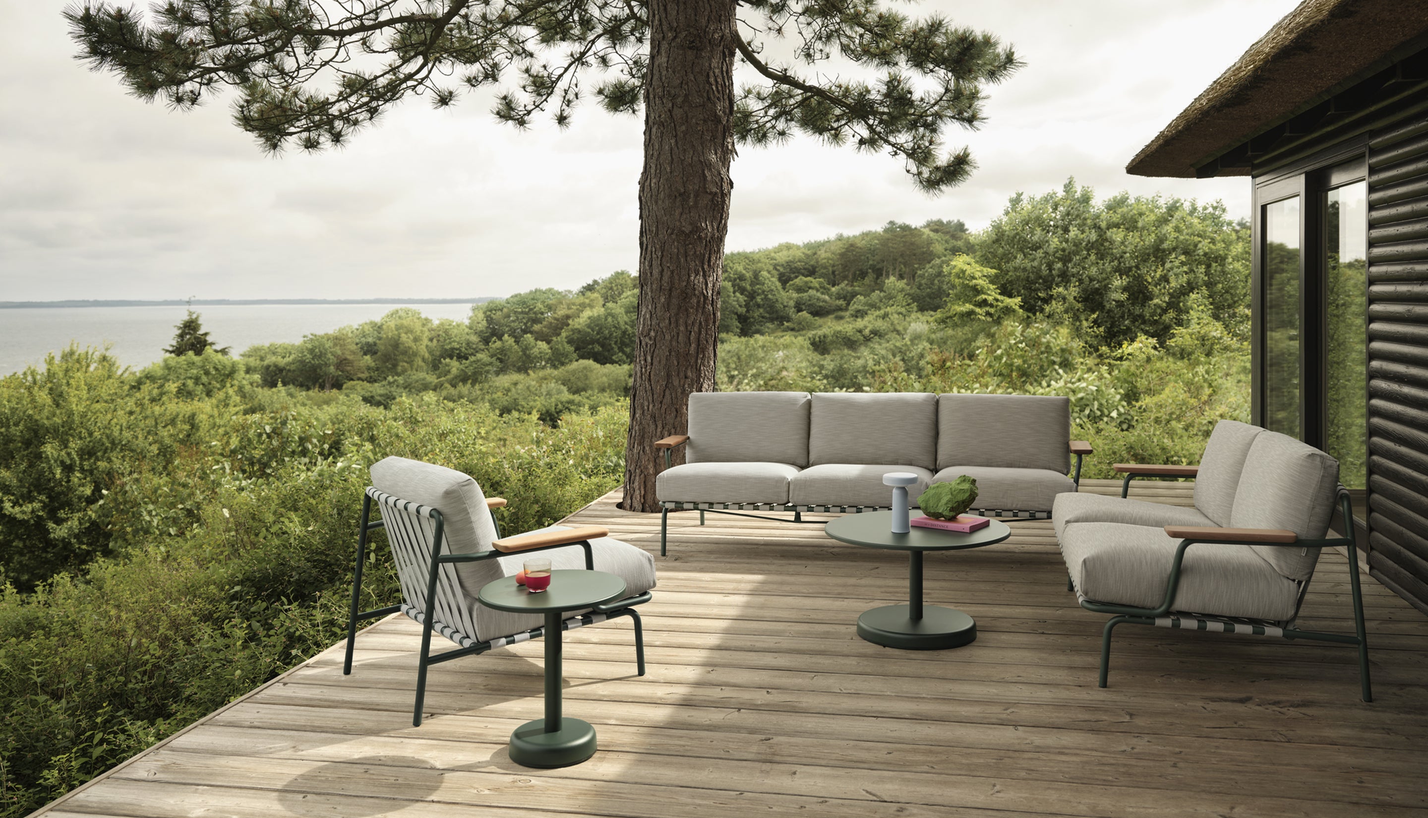 Outdoor patio furniture on wooden deck against greenery