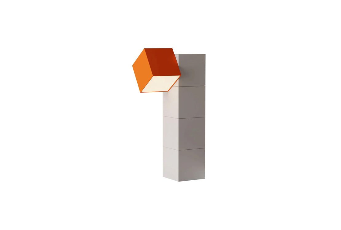 A modern geometric wall lamp featuring a vertical stack of four white rectangular blocks supporting a single orange cube shade, shown against a solid white background.