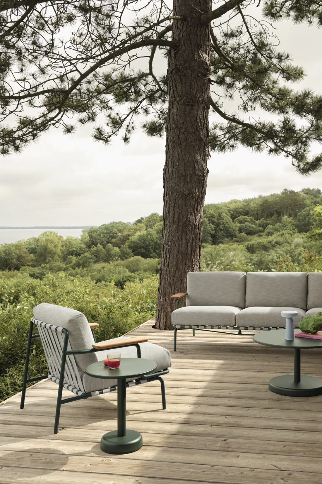 Outdoor patio furniture on wooden deck against greenery