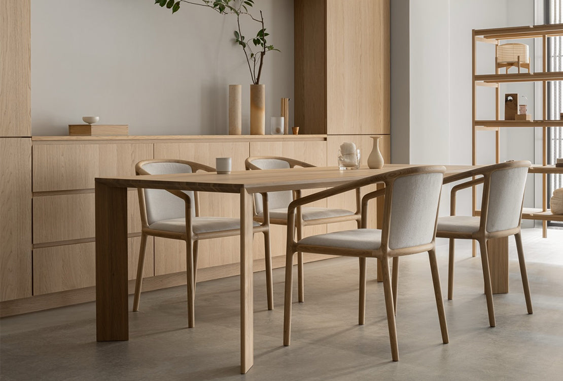 Dining area with wooden table and chairs in a modern interior setting.