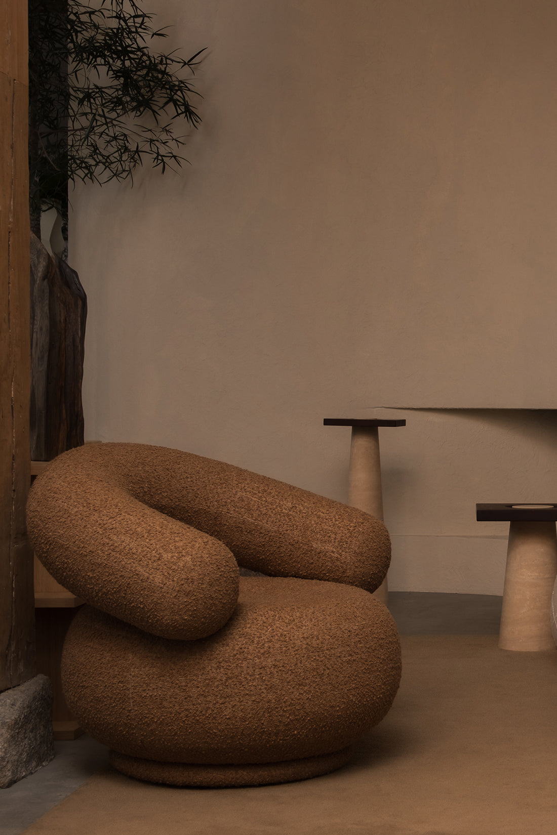 Brown textured chair in a minimalistic room with neutral walls and a small table.