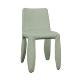 A pale sage green dining chair fully covered in diamond-quilted fabric, with thick rounded legs