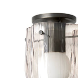 Close-up of a ceiling light with a dark metal round canopy and rippled blush-tinted glass panels around a white bulb